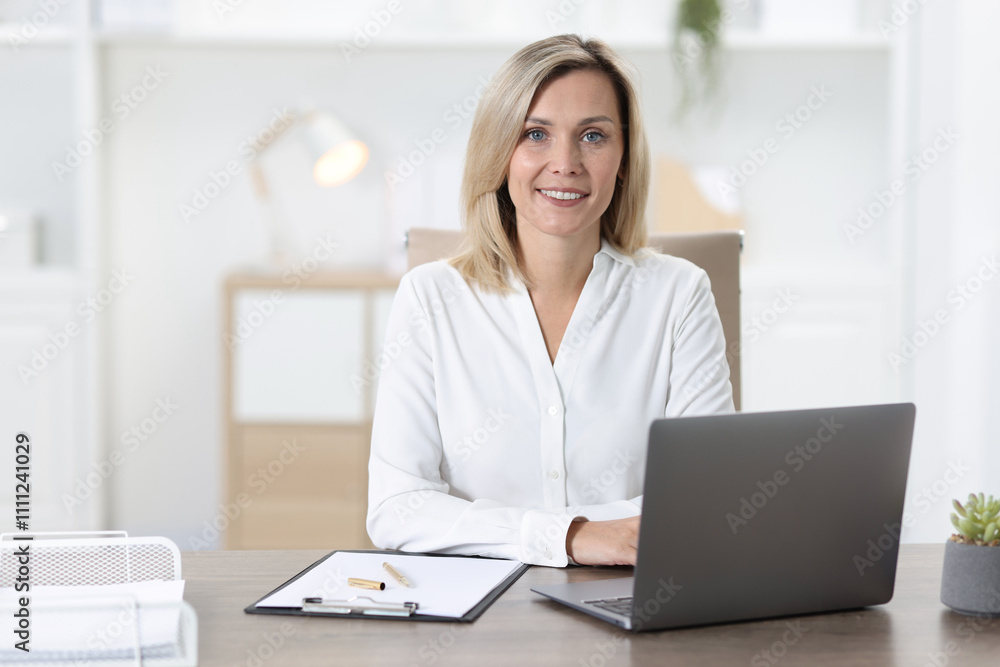 Portrait of businesswoman at table in office Portrait of businesswoman at table in office