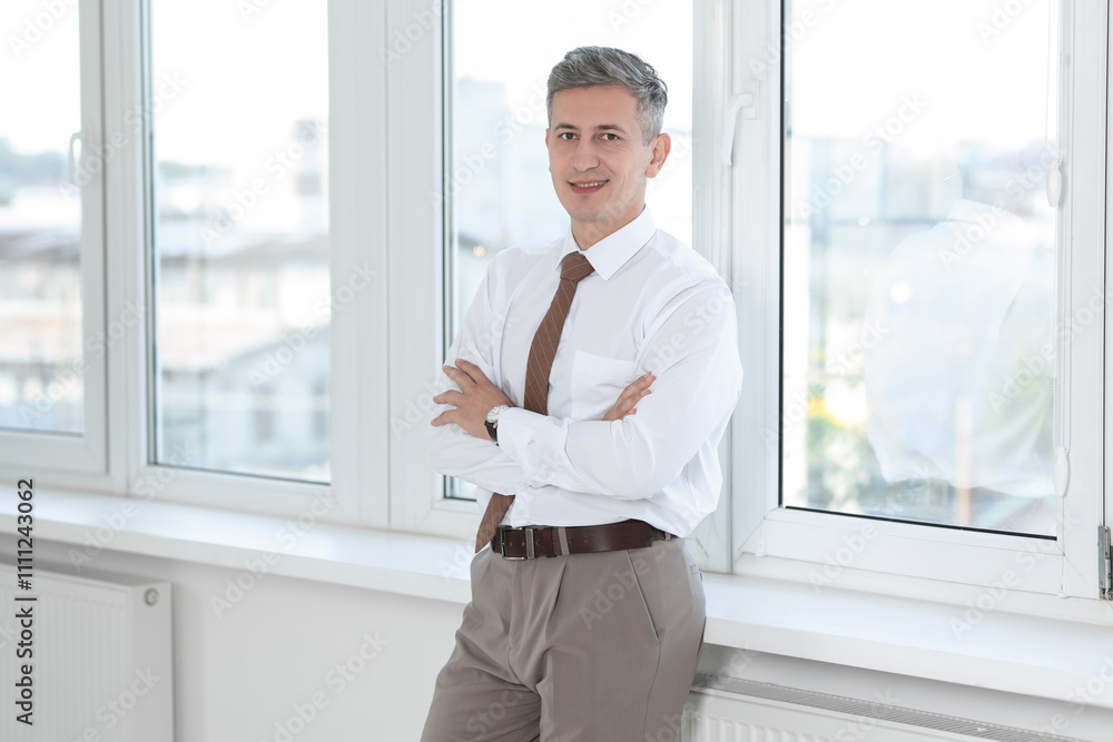 Portrait of businessman near window in office Portrait of businessman near window in office