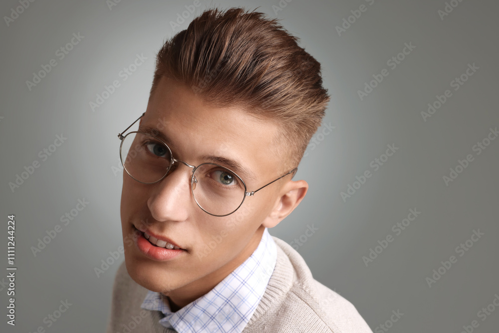 Handsome young man with stylish haircut on grey background Handsome young man with stylish haircut on grey background