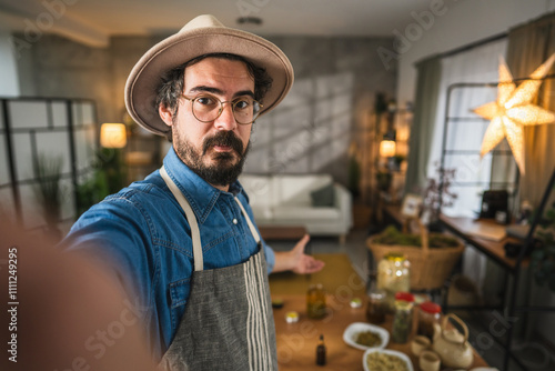 Quadro em tela Self portrait of man herbalist with his homemade product on table