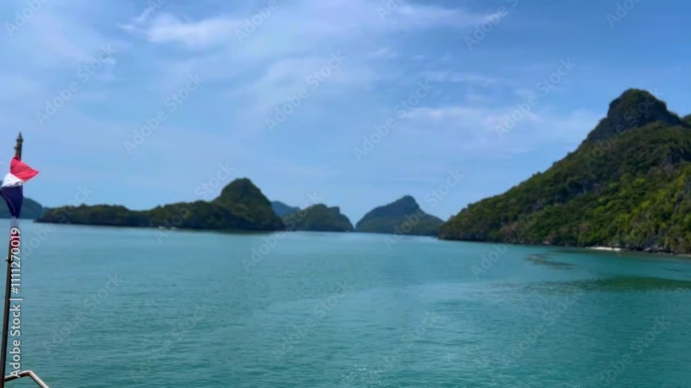 Thai flag on a tourboat moving through islands of Ang Thong National Park, Thailand Thai flag on a tourboat moving through islands of Ang Thong National Park, Thailand