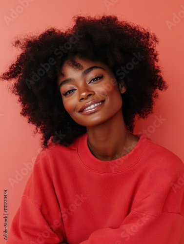 Coziness and self esteem concept. Pleased dark skinned woman with Afro hair, embraces herself, feels comfort in new sweatshirt, tilts head and smiles gently, feels fullfilled, isolated over rosy wall