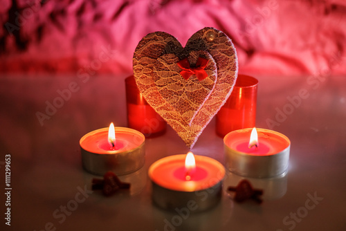 Illuminated tealight candles and red heart photo