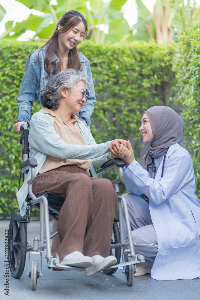 asian senior woman on wheelchair hands holding a female physiotherapist in hijab,a daughter standing behind her,health care worker empowering patient or better health asian senior woman on wheelchair hands holding a female physiotherapist in hijab,a daughter standing behind her,health care worker empowering patient or better health