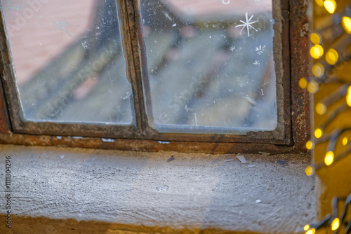 an old vintage retro window made of metal and many small glass panes is not completely airtight, cold and cold air flows through the clearly visible slits between the window and the window frame