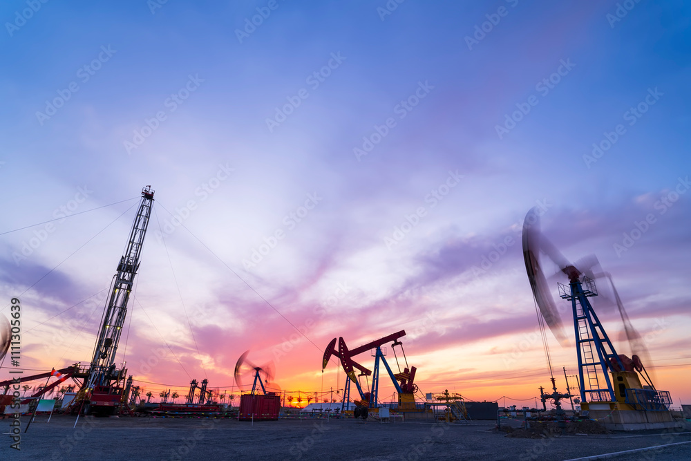 Obraz premium in the evening, oil pumps are running, The oil pump and the beautiful sunset reflected in the water, the silhouette of the beam pumping unit in the evening.