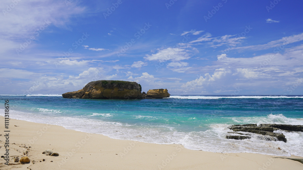 Fototapeta premium Tranquil tropical beach with a rocky outcrop.