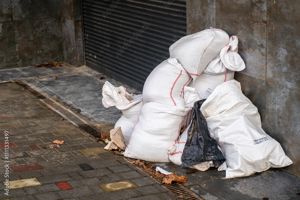 Stacked white bags of construction debris and waste waiting for disposal Stacked white bags of construction debris and waste waiting for disposal