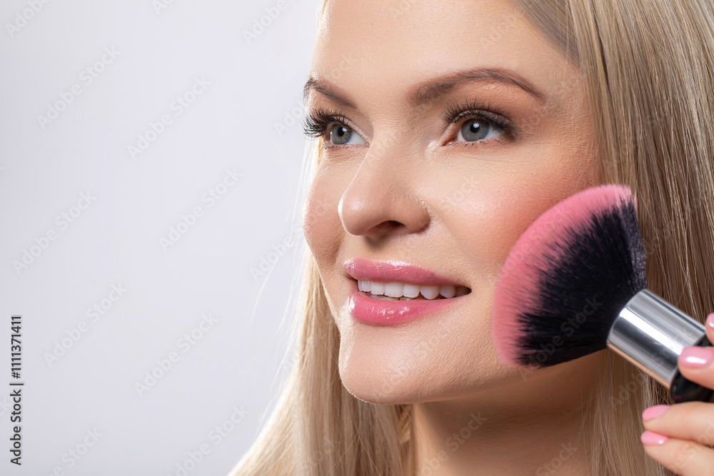 A Woman Skillfully Applying Blush with a Brush as Part of Her Daily Beauty Skincare Routine A Woman Skillfully Applying Blush with a Brush as Part of Her Daily Beauty Skincare Routine