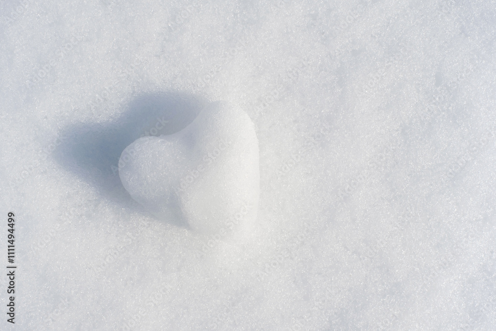 Frozen heart shaped snowball on white snow background close-up. Frozen heart shaped snowball on white snow background close-up.