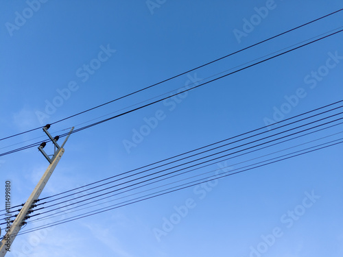 Wallpaper Mural Low angle view of electric pole and cables in public area connecting to residences, on blue sky background Torontodigital.ca