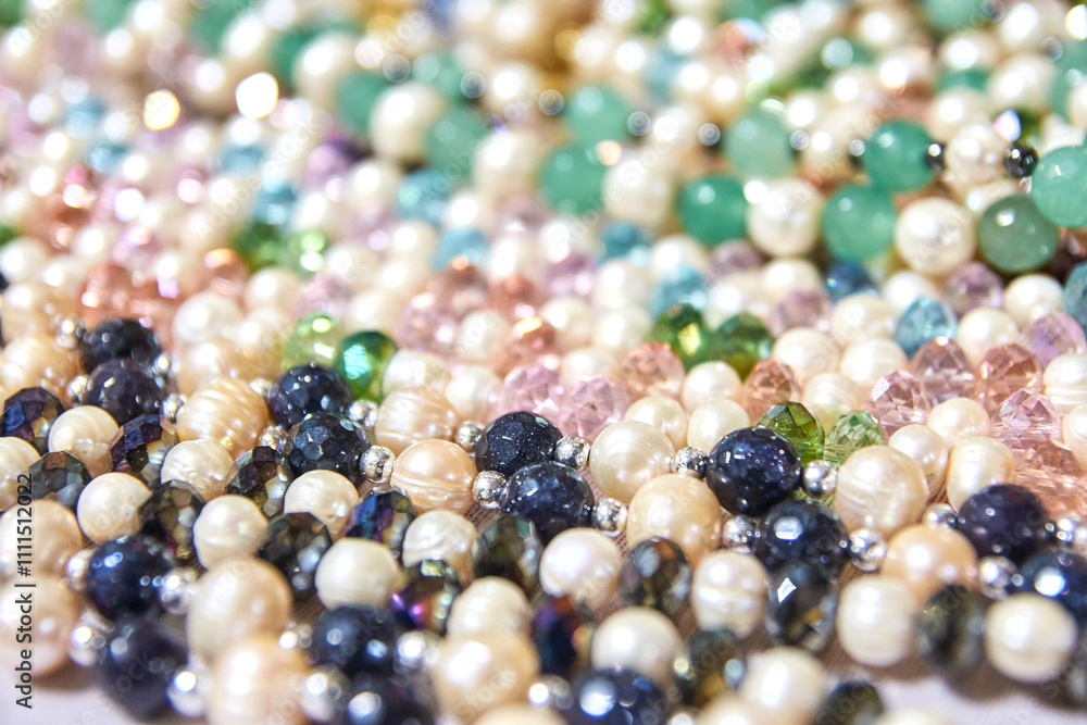 Colorful display of gemstone and pearl beads in varied shapes and sizes for jewelry making. Colorful display of gemstone and pearl beads in varied shapes and sizes for jewelry making.