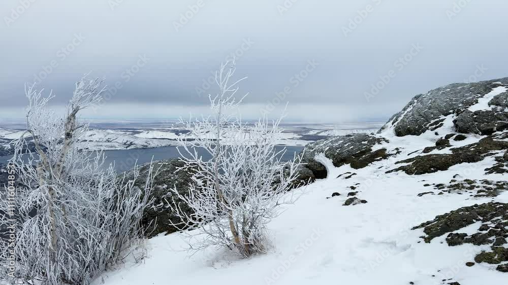 Frost-covered trees in winter mountains. Snow-covered mountains and the blue lake in the background. Frosted branches swayind in the wind. Beautiful winter landscape.
Frost-covered trees in winter mountains. Snow-covered mountains and the blue lake in the background. Frosted branches swayind in the wind. Beautiful winter landscape.