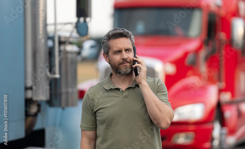 Truck driver has phone call. Trucking owner. Transportation vehicles. Hispanic man posing in front of truck. Semi trucks vehicle. Man owner truck driver. Man driver talking on phone near lorry truck photo