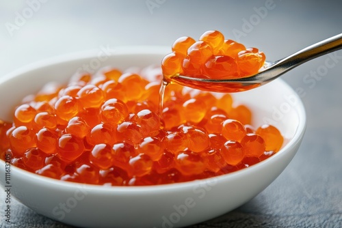 Red caviar served in a white bowl with a spoon photo