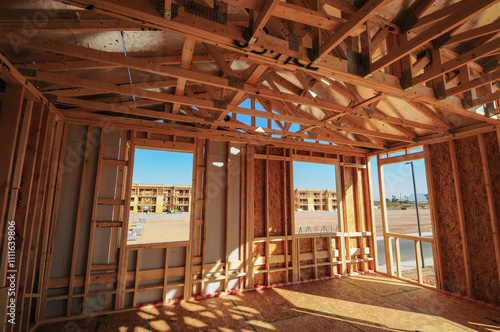 Interior wide-angle view of the framing of a room in a wooden two-story home under construction in a new subdivision photo