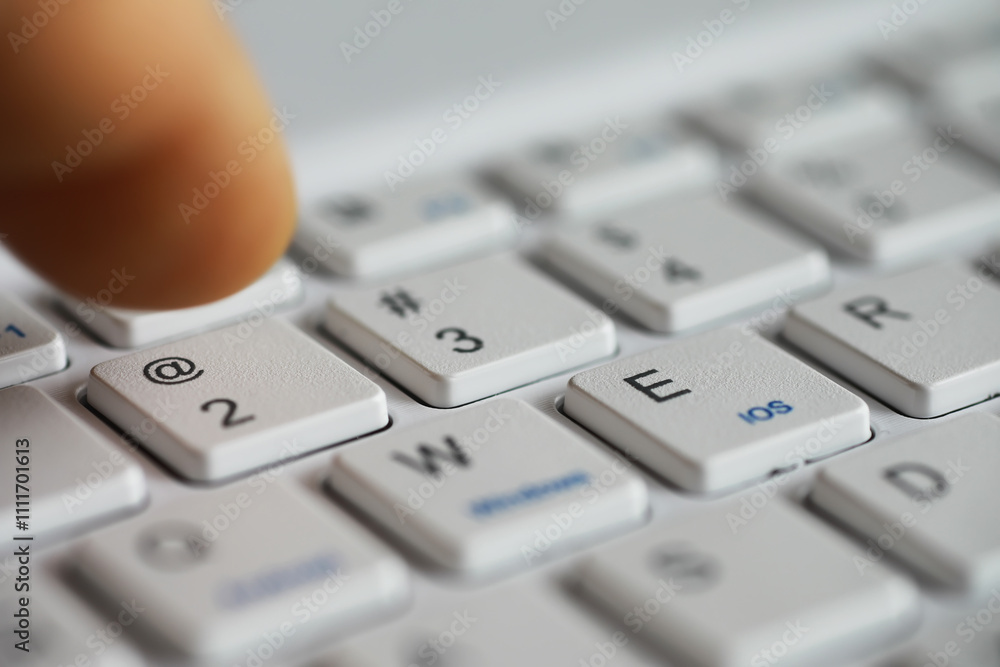 Close-up of Finger Pressing Key on White Computer Keyboard Close-up of Finger Pressing Key on White Computer Keyboard