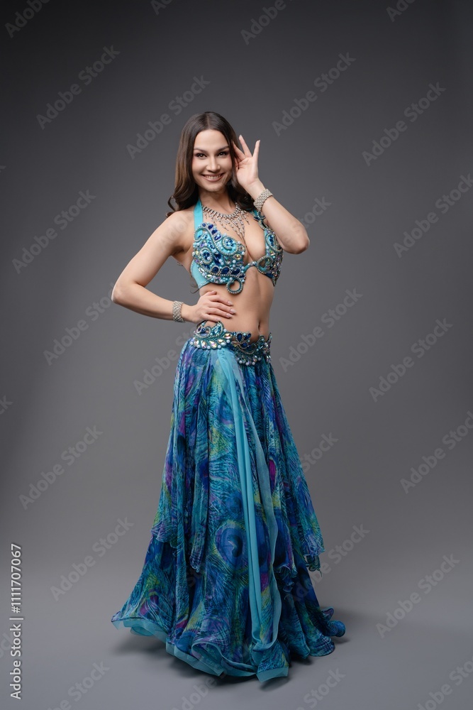 Beautiful dancer showcasing vibrant blue costume in elegant pose indoors Beautiful dancer showcasing vibrant blue costume in elegant pose indoors