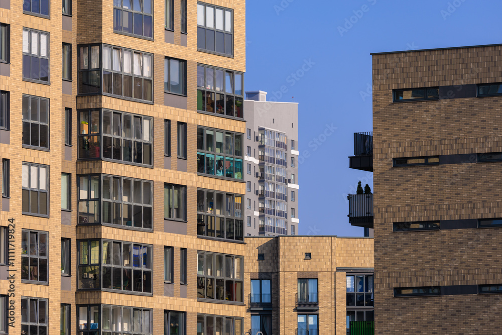 Cityscape on a summer day, modern buildings and houses against the blue sky Cityscape on a summer day, modern buildings and houses against the blue sky