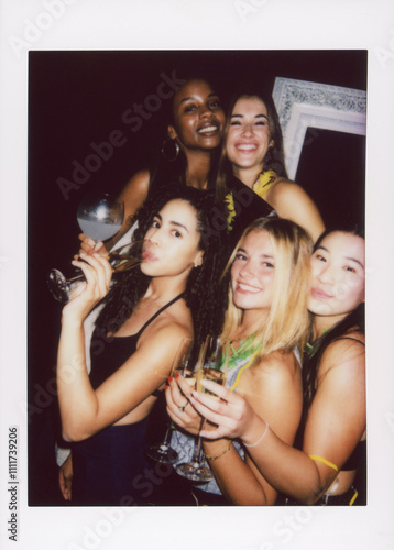 Fotografie A vintage-style instant camera photo of friends enjoying a lively party, holding drinks and smiling