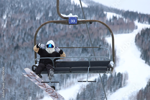 snowboarder rides happily on chairlift