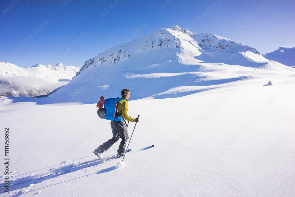 Side view of man ski touring in the Whistler backcountry Side view of man ski touring in the Whistler backcountry
