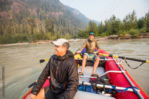 Two men laugh together during a guys weekend trip on the river photo