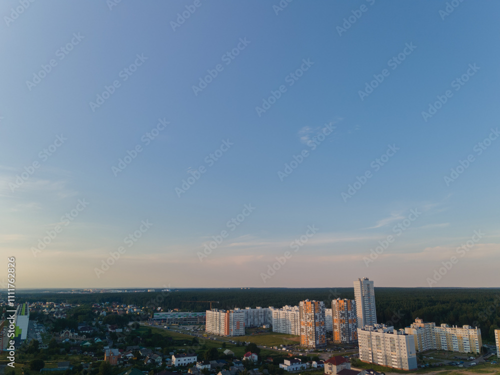 Fototapeta premium Top view of the city, landscape and buildings, sky and silhouettes of houses from the height of a flying drone. 