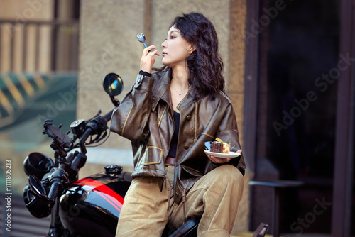 Beautiful Asian woman eating dessert on retro motorcycle outdoors