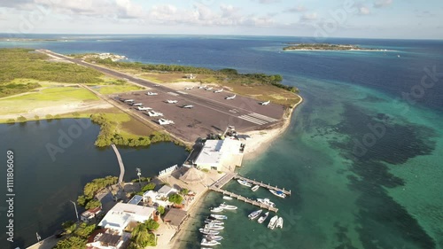 Los roques airport near turquoise caribbean waters and docked boats on a sunny day, aerial view photo