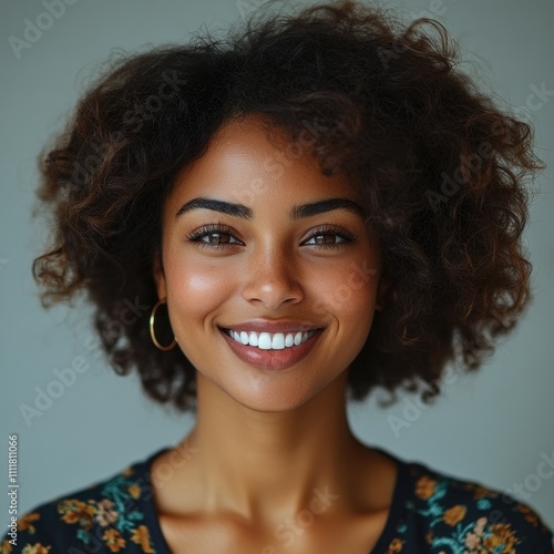 Smiling young woman with natural curly hair and hoop earrings, close-up portrait, radiant expression, glowing skin, casual beauty, confident personality, stylish female appearance, photography