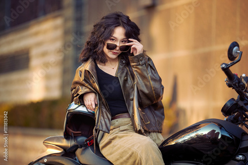 Oriental beauty taking photos on a retro motorcycle at sunset