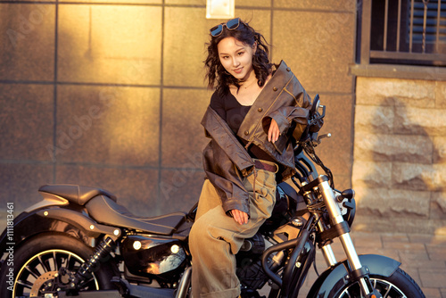 Oriental beauty taking photos on a retro motorcycle at sunset