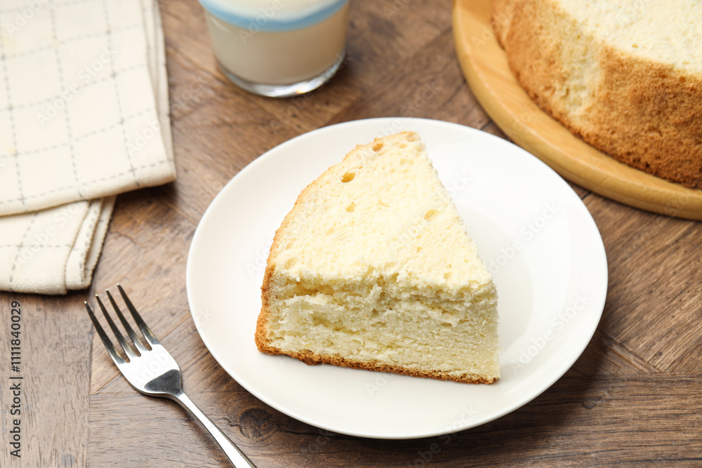 Piece of delicious sponge cake served on wooden table Piece of delicious sponge cake served on wooden table