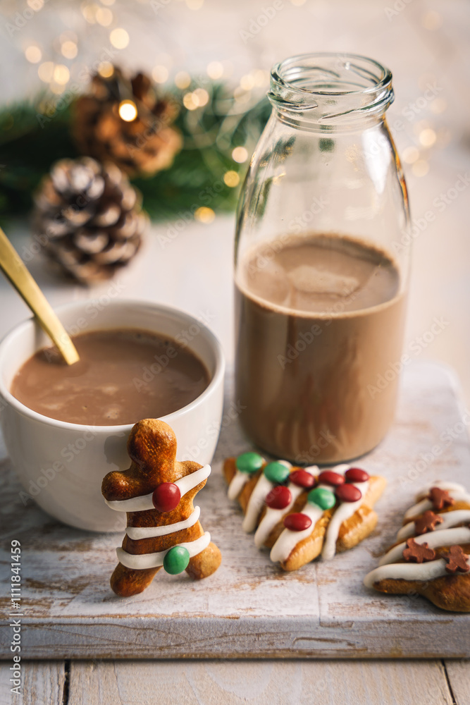 Φωτογραφία Heißer Kakao in einer Tasse und einer Glasflasche und Lebkuchen Kekse auf einem weißen Holz Tisch