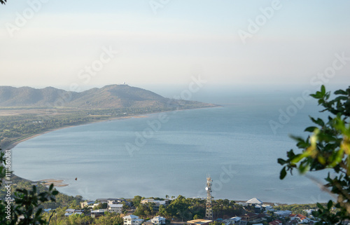 A bay with headland protruding on a clear but hazy day with blue ocean water