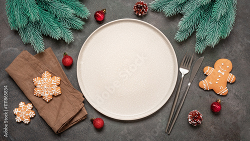 Christmas minimal table setting, empty beige plate, cutlery, gingerbread cookies and christmas decorations, top view, flat lay.