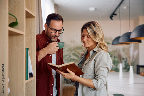 Smiling couple reading book at home. photo