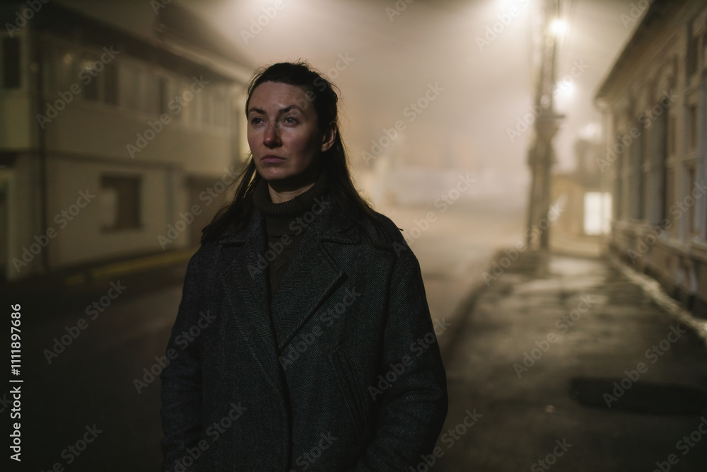 Woman walking alone on a foggy night in the city Woman walking alone on a foggy night in the city