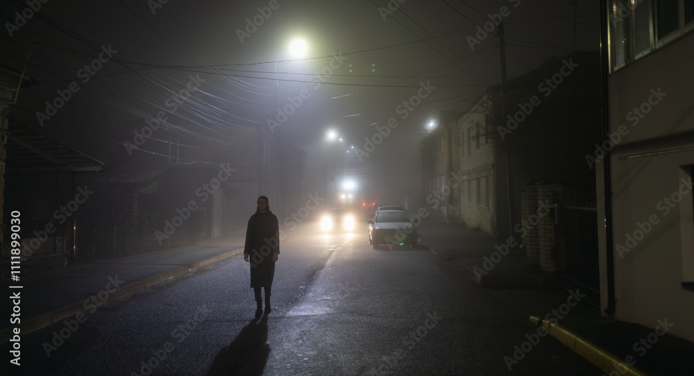 Woman walking alone on a foggy night in the city Woman walking alone on a foggy night in the city