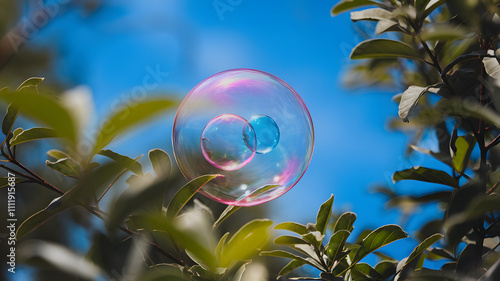 Close-up Photo of Vivid Colorful Soap Bubble Floating Against a Clear Blue Sky Surrounded by Green Branches and Fresh Leaves in Bright Natural Daylight

 photo