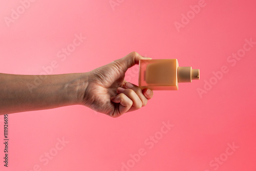 Cosmetic cream tube in womans hand on pink background  photo