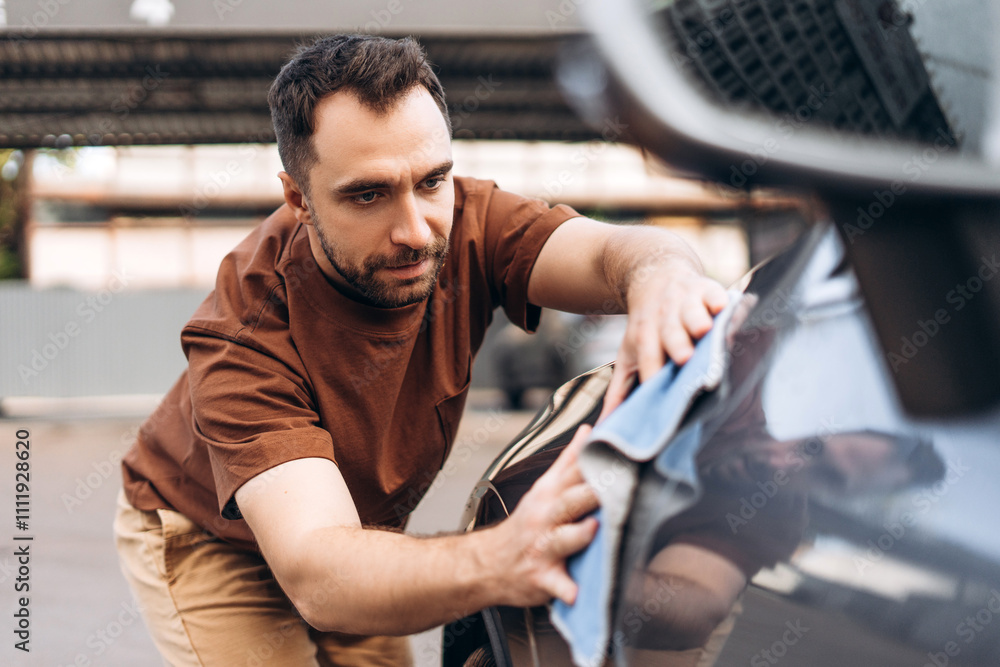 Hispanic man wiping car with microfiber at self-service car wash station. Vehicle concept Hispanic man wiping car with microfiber at self-service car wash station. Vehicle concept