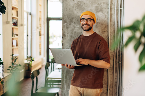 Photos Smiling happy middle aged Latin freelancer man wearing yellow hat stylish eyegla