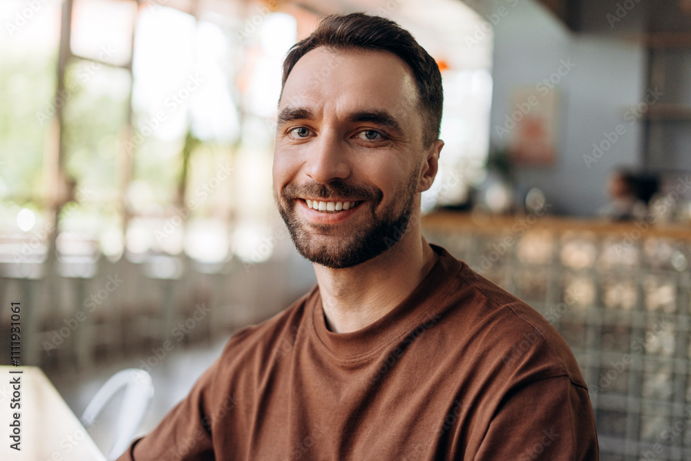 Portrait of happy smiling bearded man looking at camera, sitting in modern cafe. Dental care concept Portrait of happy smiling bearded man looking at camera, sitting in modern cafe. Dental care concept