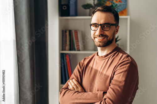 Happy, smiling bearded man, businessman wearing eyeglasses with crossed arms looking at camera