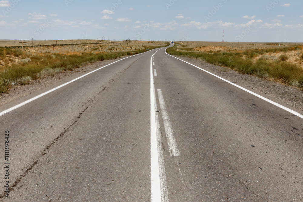 Expansive highway stretching through the scenic landscape of Kazakhstan under a clear sky Expansive highway stretching through the scenic landscape of Kazakhstan under a clear sky