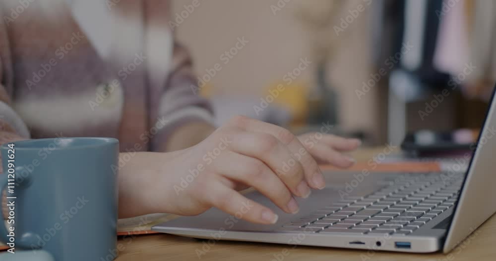 Close-up of female hands typing with laptop while woman freelancer working with computer at desk at home. Business and technology concept. Close-up of female hands typing with laptop while woman freelancer working with computer at desk at home. Business and technology concept.