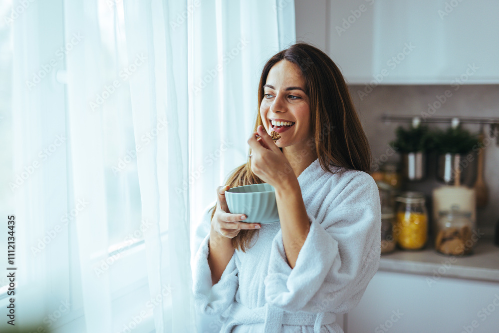 Smiling Woman Enjoying a Healthy Breakfast in Sunlit Kitchen Smiling Woman Enjoying a Healthy Breakfast in Sunlit Kitchen