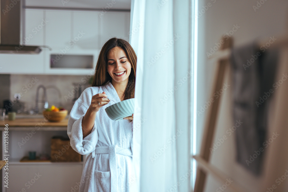 Woman Enjoying Breakfast in Modern Kitchen Wearing Cozy Bathrobe Woman Enjoying Breakfast in Modern Kitchen Wearing Cozy Bathrobe